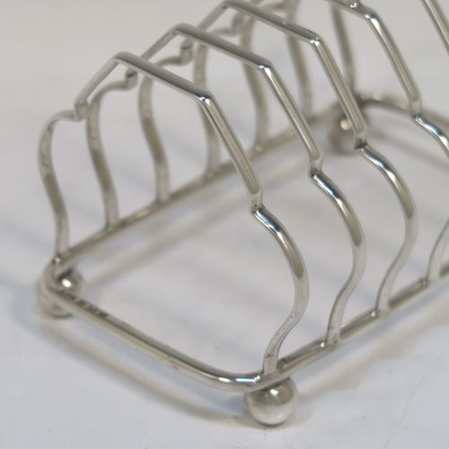 A very elegant Antique Sterling Silver seven-bar toastrack, having plain shaped cross-section wire-work bars, a matching loop handle, and all sitting on a rectangular base with four cast ball feet. This handsome antique silver toast-rack was made by Alexander Clark and Co. Ltd., of Birmingham in 1918. The dimensions of this fine hand-made antique silver toast-rack are length 13 cms (5 inches), height 12 cms (4.75 inches), width 8 cms (3.25 inches), and it weighs approx. 160g (5.2 troy ounces).