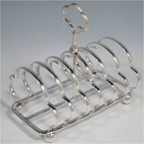 An Antique Victorian Sterling Silver large pair of seven-bar toast-racks, having shaped wire-work bars, matching loop handles, and sitting on rectangular bases with four ball feet. Made William Hutton of London in 1899/1900. The dimensions of this fine hand-made pair of silver toastracks are length 16 cms (6.25 inches), height 15 cms (6 inches), width 11 cms (4.25 inches), and they weigh approx. 612g (19.7 troy ounces).