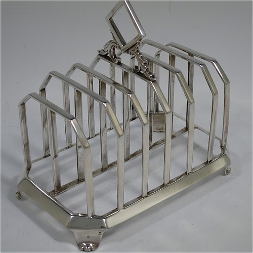 A very handsome and unusual Antique Victorian Sterling Silver seven-bar toast-rack, having plain panelled wire-work bars with central struts, a wire-work diamond-shaped handle, attached to a plain cut-corner rectangular base with a strengthening strut, and sitting on four cast flanged feet. Made by Charles and George Fox of London in 1844. The dimensions of this fine hand-made antique silver toast-rack are length 16 cms (6.3 inches), height 15 cms (6 inches), width 10 cms (4 inches), and it weighs approx. 375g (12 troy ounces).