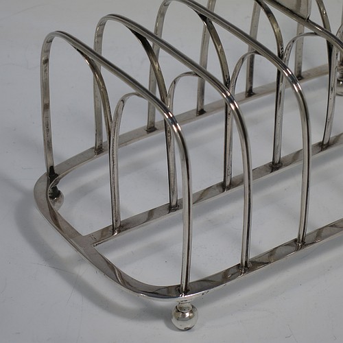 A very handsome Antique Georgian Sterling Silver seven-bar toast-rack, having rectangular shaped wire-work bars with hand-chased reeded decoration, a rectangular handle with vacant cartouche panel below, all attached to a flat rectangular base with strengthening struts, and sitting on four ball feet. Made by Joseph Biggs of London in 1816. The dimensions of this fine hand-made antique silver toast-rack are length 17 cms (6.75 inches), height 11 cms (4.25 inches), width 9 cms (3.5 inches), and it weighs approx. 162g (5.2 troy ounces).