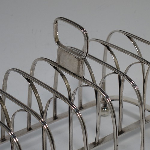 A very handsome Antique Georgian Sterling Silver seven-bar toast-rack, having rectangular shaped wire-work bars with hand-chased reeded decoration, a rectangular handle with vacant cartouche panel below, all attached to a flat rectangular base with strengthening struts, and sitting on four ball feet. Made by Joseph Biggs of London in 1816. The dimensions of this fine hand-made antique silver toast-rack are length 17 cms (6.75 inches), height 11 cms (4.25 inches), width 9 cms (3.5 inches), and it weighs approx. 162g (5.2 troy ounces).