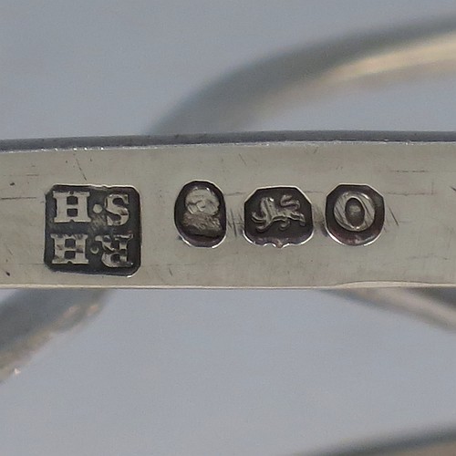 A very large and heavy Antique Georgian Sterling Silver seven-bar toast-rack, having shaped wire-work bars, a cast shell and loop handle, attached to a rectangular base with a strengthening strut, and sitting on four cast shell feet. Made by Robert and Samuel Hennell of London in 1809. The dimensions of this fine hand-made antique silver toast-rack are length 18.5 cms (7.25 inches), height 18.5 cms (7.25 inches), width 14 cms (5.5 inches), and it weighs approx. 550g (17.7 troy ounces).
