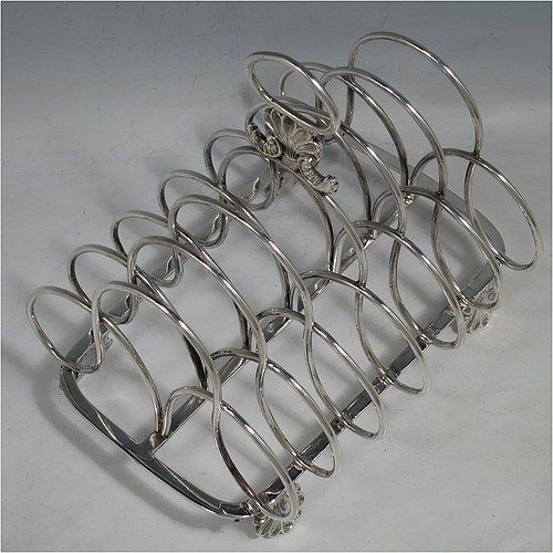 A very large and heavy Antique Georgian Sterling Silver seven-bar toast-rack, having shaped wire-work bars, a cast shell and loop handle, attached to a rectangular base with a strengthening strut, and sitting on four cast shell feet. Made by Robert and Samuel Hennell of London in 1809. The dimensions of this fine hand-made antique silver toast-rack are length 18.5 cms (7.25 inches), height 18.5 cms (7.25 inches), width 14 cms (5.5 inches), and it weighs approx. 550g (17.7 troy ounces).
