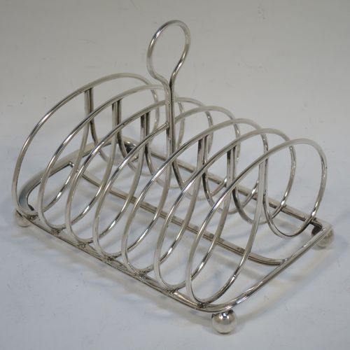 A very handsome Antique Georgian Sterling Silver seven-bar toast-rack, having oval shaped wire-work bars, a loop handle, attached to a rectangular base with a strengthening strut, and sitting on four ball feet. Made by Robinson, Edkins, and Aston of London in 1834. The dimensions of this fine hand-made antique silver toast-rack are length 15 cms (6 inches), height 12 cms (4.75 inches), width 11.5 cms (4.5 inches), and it weighs approx. 242g (7.8 troy ounces).    