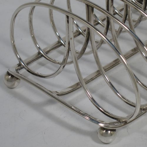 A very handsome Antique Georgian Sterling Silver seven-bar toast-rack, having oval shaped wire-work bars, a loop handle, attached to a rectangular base with a strengthening strut, and sitting on four ball feet. Made by Robinson, Edkins, and Aston of London in 1834. The dimensions of this fine hand-made antique silver toast-rack are length 15 cms (6 inches), height 12 cms (4.75 inches), width 11.5 cms (4.5 inches), and it weighs approx. 242g (7.8 troy ounces).