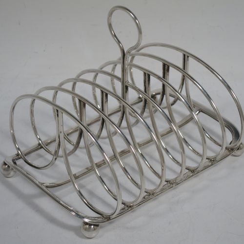 A very handsome Antique Georgian Sterling Silver seven-bar toast-rack, having oval shaped wire-work bars, a loop handle, attached to a rectangular base with a strengthening strut, and sitting on four ball feet. Made by Robinson, Edkins, and Aston of London in 1834. The dimensions of this fine hand-made antique silver toast-rack are length 15 cms (6 inches), height 12 cms (4.75 inches), width 11.5 cms (4.5 inches), and it weighs approx. 242g (7.8 troy ounces).
