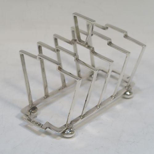 A very stylish Art Deco Sterling Silver five-bar toast-rack, in a very angular style design, attached to a rectangular base and sitting on four round cushion feet. this elegant silver toastrack was made by Alexander Clark and Co., of Birmingham in 1932. The dimensions of this fine hand-made Art Deco silver toast-rack are length 13.5 cms (5.25 inches), height 10 cms (4 inches), width 7 cms (2.75 inches), and it weighs approx. 127g (4 troy ounces).