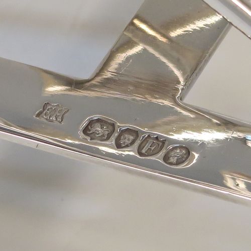 A very unusual Arts and Crafts style Antique Victorian Sterling Silver five-bar toastrack, having square crossed wire-work bars, with a square loop handle, and sitting on a base with a strengthening strut and four fluted and flanged feet. This elegant Arts and Crafts silver toast-rack was made by Edward Hutton of London in 1881. The dimensions of this fine hand-made antique silver toast-rack are length 12.5 cms (5 inches), height 11 cms (4.3 inches), width 9 cms (3.5 inches), and it weighs approx. 259g (8.4 troy ounces).
