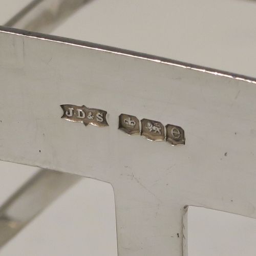 An elegant Antique Art Deco Sterling Silver seven-bar toast-rack, in a very angular style design, with a square-shaped handle, all attached to a rectangular base with strengthening strut, and sitting on multiple legs. This handsome silver toastrack was made by James Dixon and Sons of Sheffield in 1922. The dimensions of this fine hand-made Art Deco antique silver toast-rack are length 13.5 cms (5.25 inches), height 13.5 cms (5.25 inches), width 7 cms (2.75 inches), and it weighs approx. 212g (6.8 troy ounces).