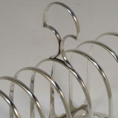 A handsome and heavy Antique Victorian Sterling Silver seven-bar toastrack, having plain rounded wire-work bars, a matching loop handle, all sitting on a rectangular base with a strengthening strut. This elegant antique silver toast-rack was made by William Hutton of London in 1898. The dimensions of this fine hand-made antique silver toast-rack are length 15 cms (6 inches), height 15 cms (6 inches), width 8 cms (3 inches), and it weighs approx. 305g (9.8 troy ounces).