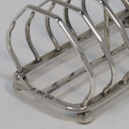 A very elegant Antique Victorian Sterling Silver seven-bar toastrack, having plain shaped cross-section wire-work bars, a matching loop handle, and all sitting on a rectangular base with four cast octagonal panelled feet. This handsome antique silver toast-rack was made by Martin and Hall of London in 1888. The dimensions of this fine hand-made antique silver toast-rack are length 13.5 cms (5.25 inches), height 11 cms (4.25 inches), width 8.5 cms (3.3 inches), and it weighs approx. 203g (6.5 troy ounces).