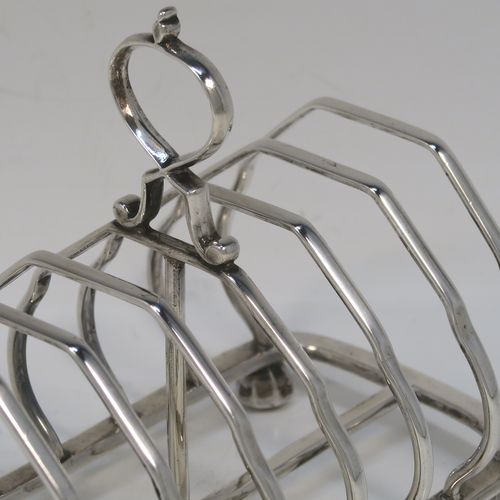 A very elegant Antique Victorian Sterling Silver seven-bar toastrack, having plain shaped cross-section wire-work bars, a matching loop handle, and all sitting on a rectangular base with four cast octagonal panelled feet. This handsome antique silver toast-rack was made by Martin and Hall of London in 1888. The dimensions of this fine hand-made antique silver toast-rack are length 13.5 cms (5.25 inches), height 11 cms (4.25 inches), width 8.5 cms (3.3 inches), and it weighs approx. 203g (6.5 troy ounces).