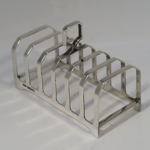 An elegant Art Deco Sterling Silver seven-bar toast-rack, in a very angular style design, with a square-shaped handle, all attached to a rectangular base, and sitting on four flange legs. This handsome silver toastrack was made by C. W. Fletcher of Sheffield in 1935. The dimensions of this fine hand-made Art Deco silver toast-rack are length 11.5 cms (4.5 inches), height 8 cms (3 inches), width 5 cms (2 inches), and it weighs approx. 91g (3 troy ounces).   
