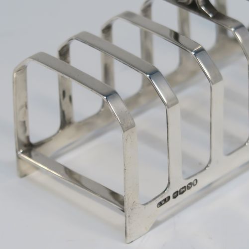An elegant Art Deco Sterling Silver seven-bar toast-rack, in a very angular style design, with a square-shaped handle, all attached to a rectangular base, and sitting on four flange legs. This handsome silver toastrack was made by C. W. Fletcher of Sheffield in 1935. The dimensions of this fine hand-made Art Deco silver toast-rack are length 11.5 cms (4.5 inches), height 8 cms (3 inches), width 5 cms (2 inches), and it weighs approx. 91g (3 troy ounces).