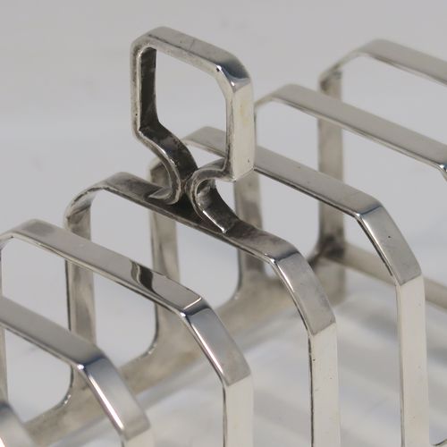 An elegant Art Deco Sterling Silver seven-bar toast-rack, in a very angular style design, with a square-shaped handle, all attached to a rectangular base, and sitting on four flange legs. This handsome silver toastrack was made by C. W. Fletcher of Sheffield in 1935. The dimensions of this fine hand-made Art Deco silver toast-rack are length 11.5 cms (4.5 inches), height 8 cms (3 inches), width 5 cms (2 inches), and it weighs approx. 91g (3 troy ounces).