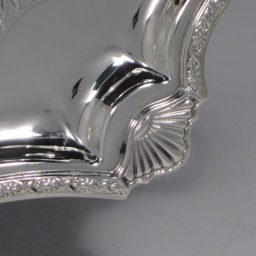 Sterling Silver Sandwich Tray, having a long shaped rectangular body, with hand-engraved ground showing a band of floral decoration, an applied floral border with shell corners, and two cast side-handles, all sitting on a flat base. This very pretty sterling silver sandwich tray was made by Mappin and Webb of Sheffield in 1929. The dimensions of this fine hand-made silver sandwich tray are length (inc. handles) 59 cms (23.25 inches), width 24 cms (9.5 inches), and it weighs approx. 1,361g (44 troy ounces).
