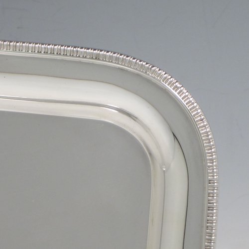 Sterling silver sandwich tray, having a rectangular body with rounded corners, a very plain ground, a raised border with an applied gadroon edge, and sitting on a flat base. Made by the Barker Brothers of Birmingham in 1921. The dimensions of this fine hand-made silver sandwich tray are length 39.5 cms (15.5 inches), width 17 cms (6.75 inches), and it weighs approx. 640g (20.6 troy ounces).