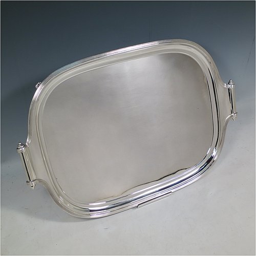 A Scottish Sterling Silver Georgian style tea tray, having a rectangular body with rounded corners, a very plain ground, an applied reeded border, two cast scroll side-handles, and sitting on four cast flanged feet. Made by Davidson, Henderson & Sorley of Glasgow in 1927. The dimensions of this fine hand-made silver tray are length (inc. handles) 44.5 cms (17.5 inches), width 31 cms (12.25 inches), and it weighs approx. 1,612g (52 troy ounces).    