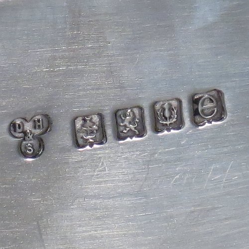 A Scottish Sterling Silver Georgian style tea tray, having a rectangular body with rounded corners, a very plain ground, an applied reeded border, two cast scroll side-handles, and sitting on four cast flanged feet. Made by Davidson, Henderson & Sorley of Glasgow in 1927. The dimensions of this fine hand-made silver tray are length (inc. handles) 44.5 cms (17.5 inches), width 31 cms (12.25 inches), and it weighs approx. 1,612g (52 troy ounces).