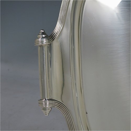A Scottish Sterling Silver Georgian style tea tray, having a rectangular body with rounded corners, a very plain ground, an applied reeded border, two cast scroll side-handles, and sitting on four cast flanged feet. Made by Davidson, Henderson & Sorley of Glasgow in 1927. The dimensions of this fine hand-made silver tray are length (inc. handles) 44.5 cms (17.5 inches), width 31 cms (12.25 inches), and it weighs approx. 1,612g (52 troy ounces).