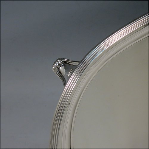 A Scottish Sterling Silver Georgian style tea tray, having a rectangular body with rounded corners, a very plain ground, an applied reeded border, two cast scroll side-handles, and sitting on four cast flanged feet. Made by Davidson, Henderson & Sorley of Glasgow in 1927. The dimensions of this fine hand-made silver tray are length (inc. handles) 44.5 cms (17.5 inches), width 31 cms (12.25 inches), and it weighs approx. 1,612g (52 troy ounces).