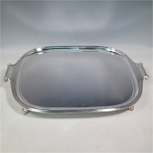 A Scottish Sterling Silver Georgian style tea tray, having a rectangular body with rounded corners, a very plain ground, an applied reeded border, two cast scroll side-handles, and sitting on four cast flanged feet. Made by Davidson, Henderson & Sorley of Glasgow in 1927. The dimensions of this fine hand-made silver tray are length (inc. handles) 44.5 cms (17.5 inches), width 31 cms (12.25 inches), and it weighs approx. 1,612g (52 troy ounces).