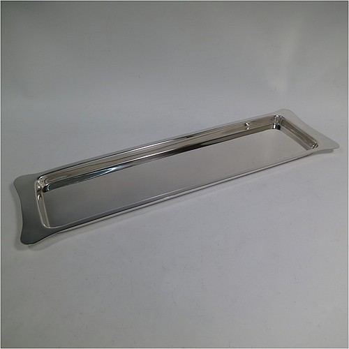 An Antique Edwardian Sterling Silver sandwich tray, having a long plain rectangular body, a very plain ground, a plain border with lobed corner handles, and sitting on a flat base. Made by Heath and Middleton of Birmingham in 1908. The dimensions of this fine hand-made antique silver sandwich tray are length 46 cms (18 inches), width 13.5 cms (5.25 inches), and it weighs approx. 506g (16.3 troy ounces). 