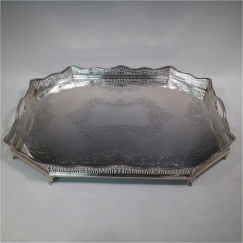 A very pretty Antique Victorian Sterling Silver gallery tray, having an elongated octagonal body, a hand-engraved ground with floral and scroll decoration, hand-pierced gallery sides with applied gadroon borders and oval cut-out handles, and sitting on eight cast shell flange feet. This beautiful silver tray was made by Charles Clement Pilling of Sheffield in 1901. The dimensions of this fine hand-made antique silver tray are length 57 cms (22.5 inches), width 41 cms (16 inches), height 8 cms (3 inches), and it weighs approx. 3,720g (120 troy ounces).    