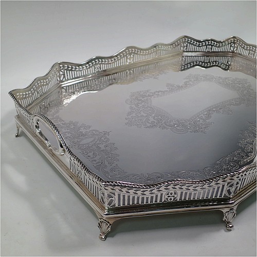 A very pretty Antique Victorian Sterling Silver gallery tray, having an elongated octagonal body, a hand-engraved ground with floral and scroll decoration, hand-pierced gallery sides with applied gadroon borders and oval cut-out handles, and sitting on eight cast shell flange feet. This beautiful silver tray was made by Charles Clement Pilling of Sheffield in 1901. The dimensions of this fine hand-made antique silver tray are length 57 cms (22.5 inches), width 41 cms (16 inches), height 8 cms (3 inches), and it weighs approx. 3,720g (120 troy ounces).