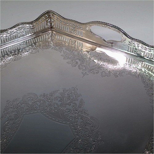 A very pretty Antique Victorian Sterling Silver gallery tray, having an elongated octagonal body, a hand-engraved ground with floral and scroll decoration, hand-pierced gallery sides with applied gadroon borders and oval cut-out handles, and sitting on eight cast shell flange feet. This beautiful silver tray was made by Charles Clement Pilling of Sheffield in 1901. The dimensions of this fine hand-made antique silver tray are length 57 cms (22.5 inches), width 41 cms (16 inches), height 8 cms (3 inches), and it weighs approx. 3,720g (120 troy ounces).