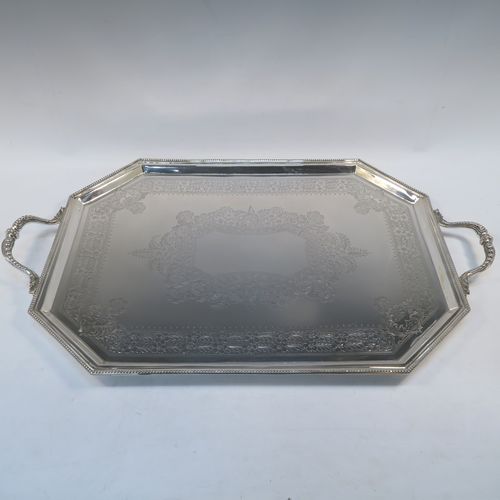 A very pretty Antique Victorian Sterling Silver tray, having an elongated octagonal body with a hand-engraved florally decorated, an applied bead-edged border, and two cast side-handles, all sitting on four round cushion feet. This beautiful silver tray was made by the Atkinson Brothers Ltd., of Sheffield in 1901. The dimensions of this fine hand-made antique silver tray are length (inc. handles) 66 cms (26 inches), width 40 cms (15.75 inches), and it weighs approx. 2,698g (87 troy ounces).   