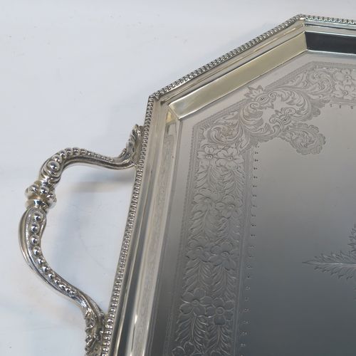 A very pretty Antique Victorian Sterling Silver tray, having an elongated octagonal body with a hand-engraved florally decorated, an applied bead-edged border, and two cast side-handles, all sitting on four round cushion feet. This beautiful silver tray was made by the Atkinson Brothers Ltd., of Sheffield in 1901. The dimensions of this fine hand-made antique silver tray are length (inc. handles) 66 cms (26 inches), width 40 cms (15.75 inches), and it weighs approx. 2,698g (87 troy ounces).