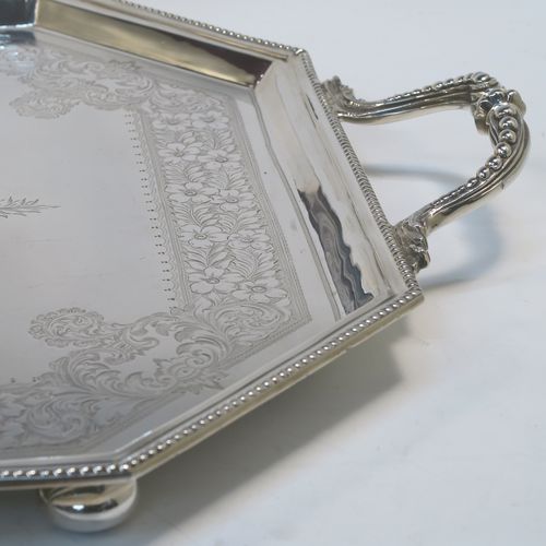 A very pretty Antique Victorian Sterling Silver tray, having an elongated octagonal body with a hand-engraved florally decorated, an applied bead-edged border, and two cast side-handles, all sitting on four round cushion feet. This beautiful silver tray was made by the Atkinson Brothers Ltd., of Sheffield in 1901. The dimensions of this fine hand-made antique silver tray are length (inc. handles) 66 cms (26 inches), width 40 cms (15.75 inches), and it weighs approx. 2,698g (87 troy ounces).