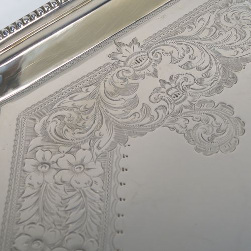 A very pretty Antique Victorian Sterling Silver tray, having an elongated octagonal body with a hand-engraved florally decorated, an applied bead-edged border, and two cast side-handles, all sitting on four round cushion feet. This beautiful silver tray was made by the Atkinson Brothers Ltd., of Sheffield in 1901. The dimensions of this fine hand-made antique silver tray are length (inc. handles) 66 cms (26 inches), width 40 cms (15.75 inches), and it weighs approx. 2,698g (87 troy ounces).