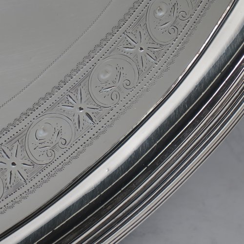An Antique Georgian Sterling silver oval two-handled tea tray, with a beautifully hand-engraved band of floral decoration, an applied reeded border with matching cast handles, and sitting on a flat base. This handsome Georgian sterling silver tray was made by Elizabeth Jones of London in 1794. The dimensions of this fine hand-made silver tray are length inc. handles 52 cms (20.5 inches), width 34 cms (13.5 inches), and it weighs approx. 1,593g (51 troy ounces).