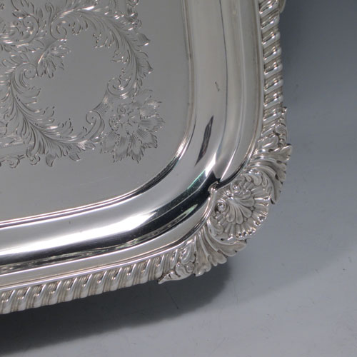 Antique Edwardian sterling silver tea tray, having a rectangular body, with applied cast gadroon and shell border, two cast handles, and a hand-engraved ground with floral decoration, all sitting on a flat base. Made by Mappin and Webb of Sheffield in 1905. The dimensions of this fine hand-made silver tea tray are length (inc. handles) 70 cms (27.5 inches), width 41 cms (16 inches), and it weighs approx. 3,410g (110 troy ounces).
