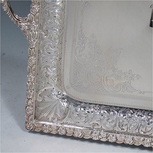A very pretty Antique Victorian Silver Plated tray, having a rectangular body, a beautiful hand-engraved ground with floral decoration surrounding a central vacant cartouche, a hand-chased border with floral and scroll decoration, with two cast gadroon side-handles, and sitting on a flat base. This beautiful silver-plated tray was made by the Mappin Brothers of Sheffield in their top-quality Queens Plate. The dimensions of this fine hand-made silver plated tea tray are length (inc. handles) 58 cms (22.75 inches), width 38 cms (15 inches).