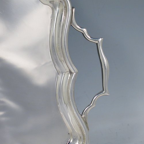 A Sterling Silver tray, having a very plain ground, with an applied Bath edged border, with two cast side-handles, and sitting on a flat base. Made by Bert Gordon of Birmingham in 1949. The dimensions of this fine hand-made silver tray are length (inc. handles) 40 cms (15.75 inches), width 22 cms (8.5 inches), and it weighs approx. 884g (28.5 troy ounces).