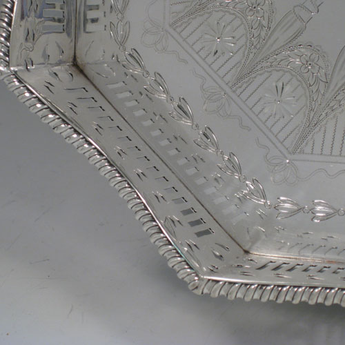 Antique Victorian sterling silver gallery tray, having an octagonal body, with an engraved ground with neoclassical style hand-engraving, a hand-pierced gallery border with shaped gadroon edge and cut-out handles, all sitting on four cast foliate feet. This very handsome sterling silver tray was made by Page, Keen, and Page of London in 1901. The dimensions of this fine hand-made silver gallery tray are length 53 cms (21 inches), width 35 cms (13.75 inches), height 8.5 cms (3.3 inches), and it weighs approx. 3,161g (102 troy ounces).