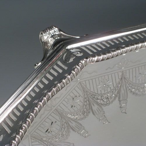 Antique Victorian sterling silver gallery tray, having an octagonal body, with an engraved ground with neoclassical style hand-engraving, a hand-pierced gallery border with shaped gadroon edge and cut-out handles, all sitting on four cast foliate feet. This very handsome sterling silver tray was made by Page, Keen, and Page of London in 1901. The dimensions of this fine hand-made silver gallery tray are length 53 cms (21 inches), width 35 cms (13.75 inches), height 8.5 cms (3.3 inches), and it weighs approx. 3,161g (102 troy ounces).