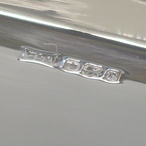 A very handsome and stylish Art Deco Sterling silver tray, having a very plain ground, a raised gallery border with rounded corners, two side-handles, and sitting on a flat base. This elegant Art Deco silver tray was made by Walker and Hall of Sheffield in 1932. The dimensions of this fine hand-made silver tray are length (inc. handles) 38 cms (15 inches), width 18.5 cms (7.25 inches), and it weighs approx. 620g (20 troy ounces).