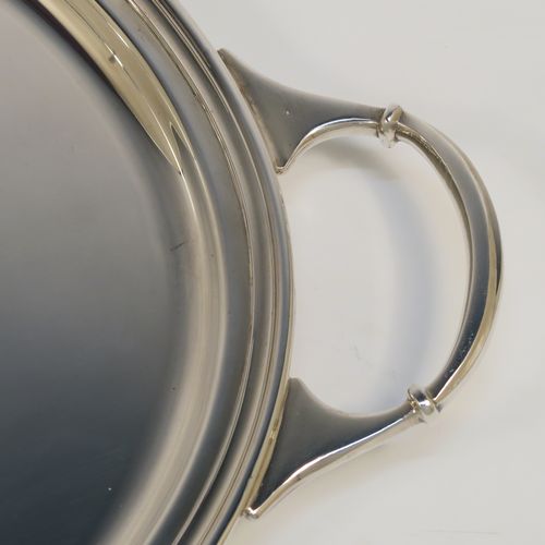 A very elegant Sterling Silver oval two-handled tea tray, having a plain ground, with an applied Reeded border, two cast side handles, and all sitting on four cast claw and ball feet. This very handsome silver tray was made by Sydney Segal of Sheffield in 1972. The dimensions of this fine hand-made silver tray are length (inc. handles) 51 cms (20 inches), width 33 cms (13 inches), and it weighs approx. 1,798g (58 troy ounces).