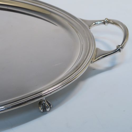 A very elegant Sterling Silver oval two-handled tea tray, having a plain ground, with an applied Reeded border, two cast side handles, and all sitting on four cast claw and ball feet. This very handsome silver tray was made by Sydney Segal of Sheffield in 1972. The dimensions of this fine hand-made silver tray are length (inc. handles) 51 cms (20 inches), width 33 cms (13 inches), and it weighs approx. 1,798g (58 troy ounces).