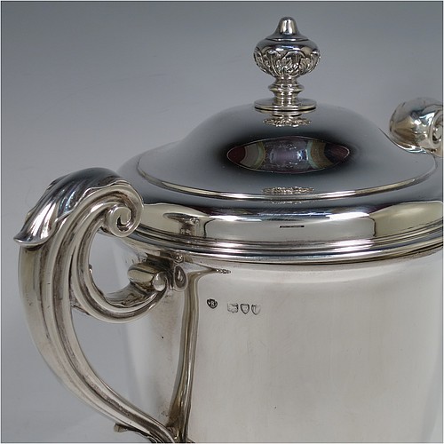 A very handsome and heavy Antique Victorian Sterling Silver trophy cup and cover, in a George II style, having a plain round body, two flying scroll side-handles with anthemion leaf thumb-pieces, a pull-off lid with cast finial, and all sitting on a stepped pedestal foot. Made by William Barnard of London in 1895. The dimensions of this fine hand-made antique silver trophy cup and cover are height 27 cms (10.5 inches), spread across arms 30.5 cms (12 inches), and it weighs approx. 1,787g (57.6 troy ounces).