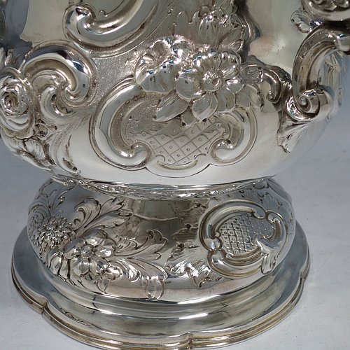 An impressive Antique Victorian Sterling Silver trophy cup, in a Campana style, having a bellied body with cartouches on both sides, with hand-chased floral and scroll decoration, with two floral scroll handles, and sitting on a pedestal foot. This beautiful antique silver trophy cup was made by Charles Boyton of London in 1861. The dimensions of this fine hand-made antique silver trophy cup are height 26 cms (10.25 inches), spread across handles 30 cms (11.75 inches), and it weighs approx. 1,291g (42 troy ounces). Please note that this item is crested on one side.