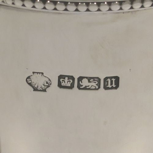 A small but very elegant Antique Sterling Silver trophy cup and cover in a George III neoclassical style, having a round plain body with tapering sides, with applied bead-edged borders, two looped side-handles, an original cover with matching decoration and cast urn finial, and all sitting on a pedestal foot. This handsome silver trophy cup was made by William Hutton of Sheffield in 1912. The dimensions of this fine hand-made silver trophy cup and cover are height 20 cms (8 inches), spread across arms 12.5 cms (5 inches), and it weighs approx. 280g (9 troy ounces).   