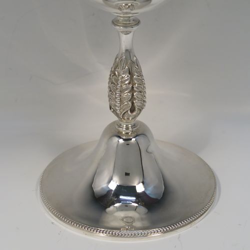 A large and handsome Antique Edwardian Silver-Plated goblet style trophy cup, having a plain round bellied body, sitting on a plain round pedestal foot with an applied bead-edged border, and with a cast floral central leaf stem. This elegant silver plated goblet trophy was made by Mappin and Webb of London in ca. 1910. The dimensions of this large and fine hand-made antique silver-plated trophy goblet cup are height 28 cms (11 inches), and diameter at lip 12 cms (4.75 inches).