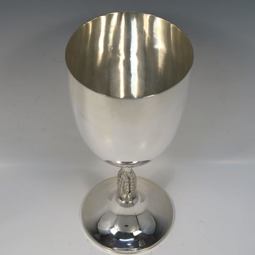 A large and handsome Antique Edwardian Silver-Plated goblet style trophy cup, having a plain round bellied body, sitting on a plain round pedestal foot with an applied bead-edged border, and with a cast floral central leaf stem. This elegant silver plated goblet trophy was made by Mappin and Webb of London in ca. 1910. The dimensions of this large and fine hand-made antique silver-plated trophy goblet cup are height 28 cms (11 inches), and diameter at lip 12 cms (4.75 inches).