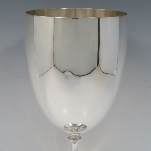 A large and handsome Antique Edwardian Silver-Plated goblet style trophy cup, having a plain round bellied body, sitting on a plain round pedestal foot with an applied bead-edged border, and with a cast floral central leaf stem. This elegant silver plated goblet trophy was made by Mappin and Webb of London in ca. 1910. The dimensions of this large and fine hand-made antique silver-plated trophy goblet cup are height 28 cms (11 inches), and diameter at lip 12 cms (4.75 inches).