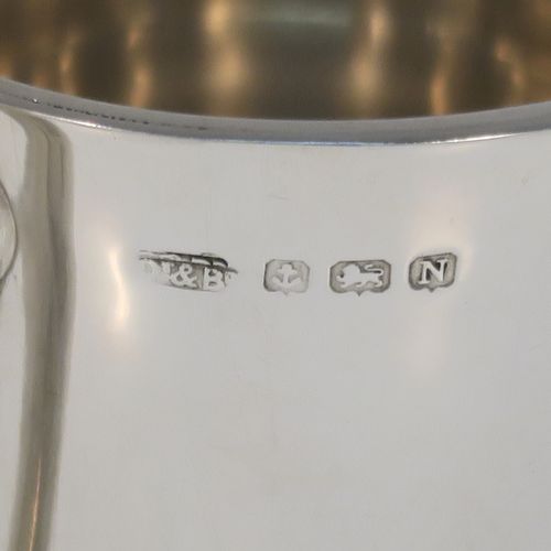 A small but but handsome Sterling Silver three-handled Loving cup, having a plain round bellied body, with three cast scroll side handles, and all sitting on a round pedestal foot. This elegant silver loving cup trophy was made by Ollivant and Botsford of Birmingham in 1937. The dimensions of this fine hand-made sterling silver trophy cup are height 9.5 cms (3.75 inches), diameter of main body 7 cms (2.75 inches), and it weighs approx. 180g (5.8 troy ounces).   
